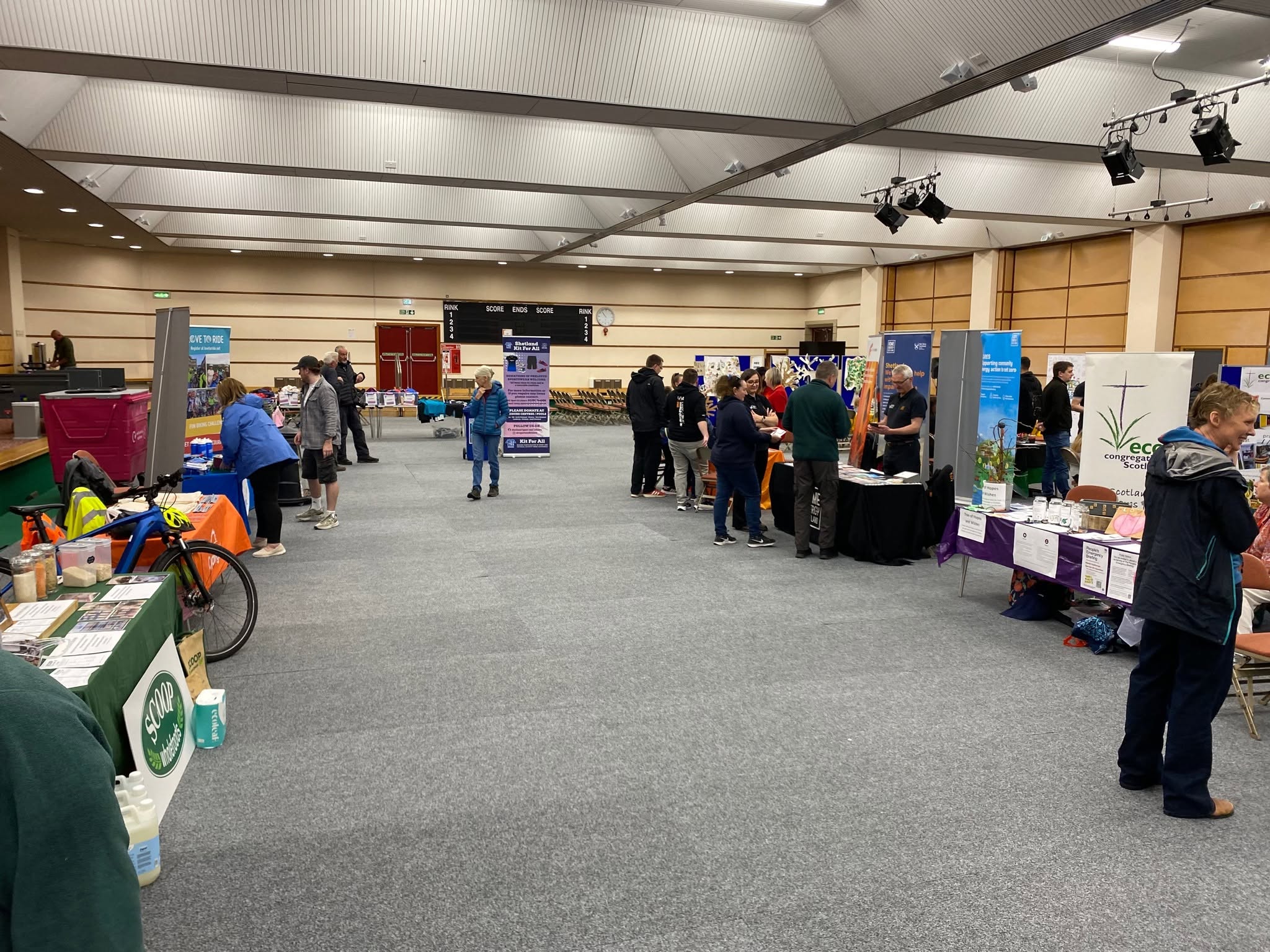 Visitors exploring exhibitors’ stalls in the Clickimin hall at the 2026 Shetland Climate Festival